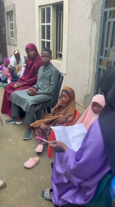 Children seated in the school compound with books