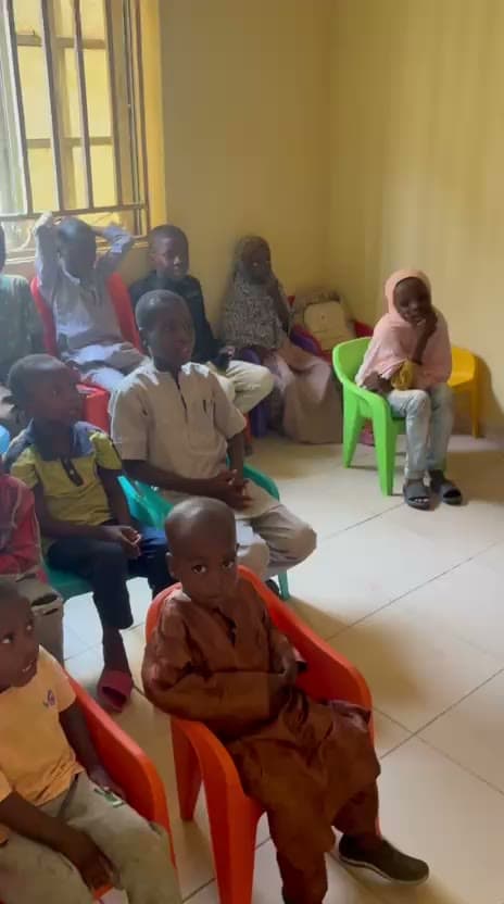 Children seated in a classroom listening to their teacher